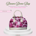 A structured dome-shaped handbag with a pink and purple camouflage pattern, displayed on a white tiered pedestal against a light pink background with promotional text.