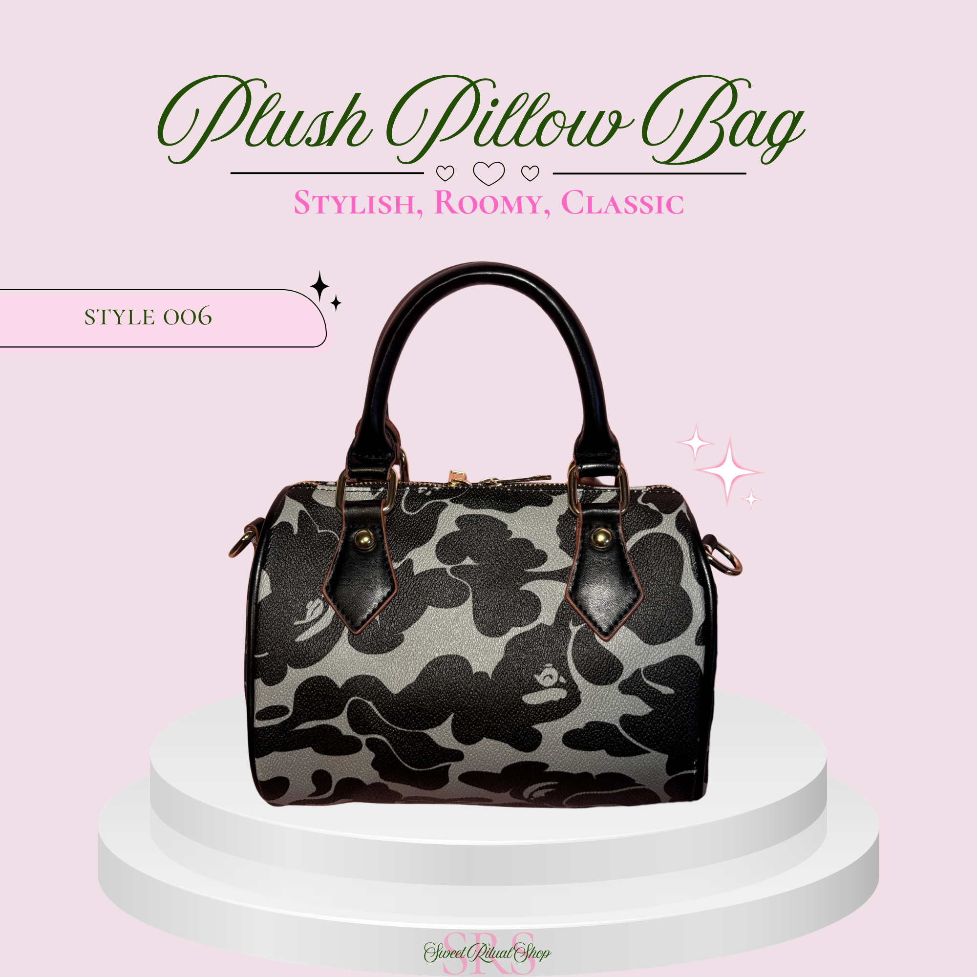 A plush pillow-style handbag with a black and gray abstract cloud pattern, displayed on a white tiered pedestal against a light pink background with decorative text and sparkles.